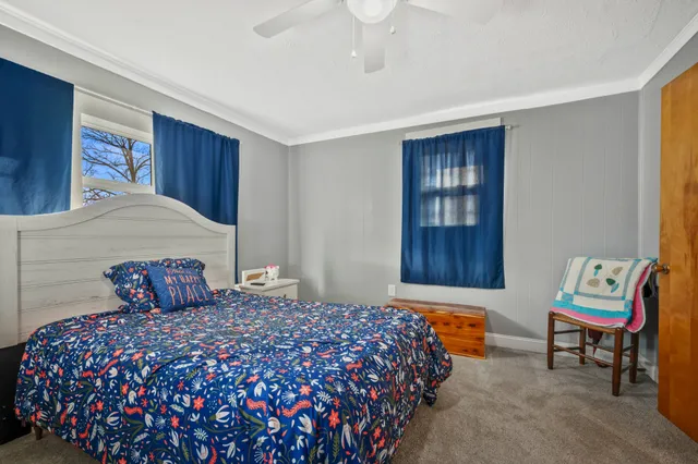 a bedroom with a bed and a lamp on dresser