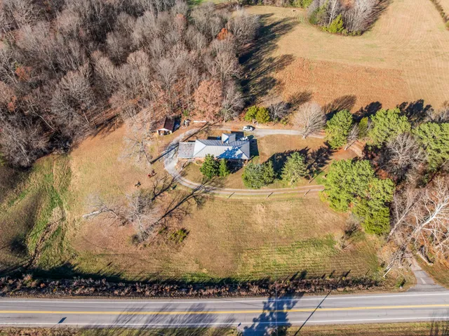 a view of a yard with cars parked on the road