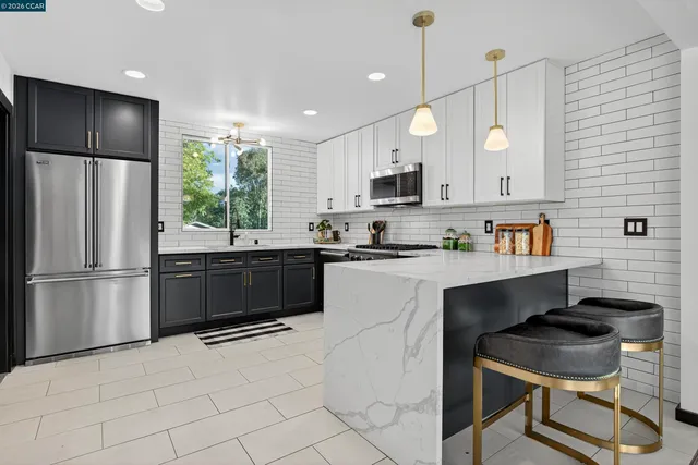 a kitchen with kitchen island a counter space a sink appliances and cabinets