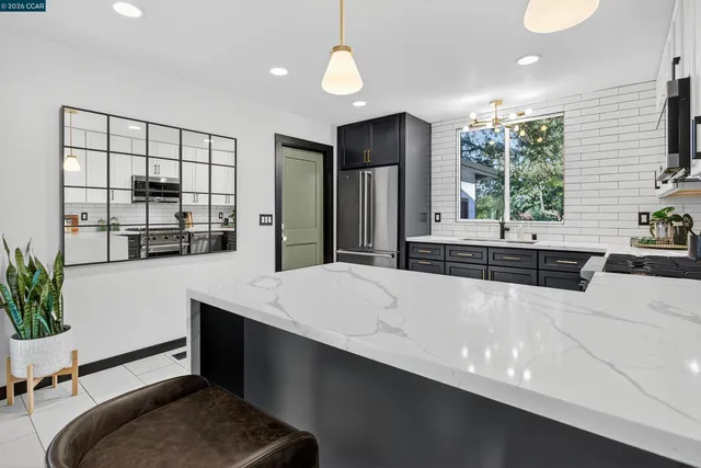 a living room with stainless steel appliances kitchen island granite countertop furniture and a large window