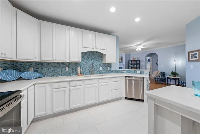 a large white kitchen with sink and cabinets