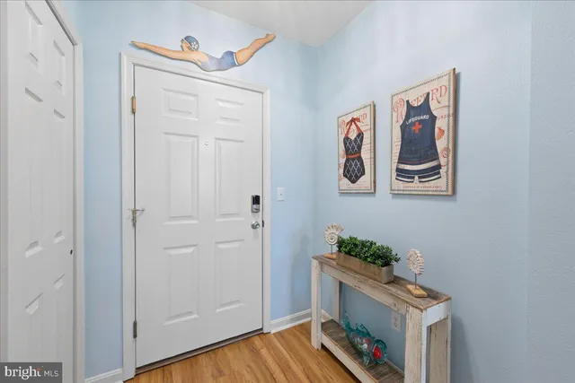 a hallway with painting on the wall and a potted plant