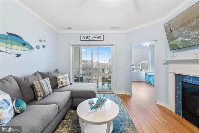 a living room with furniture a fireplace and a dining table with wooden floor