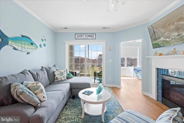 a living room with furniture a fireplace a large window and a flat screen tv