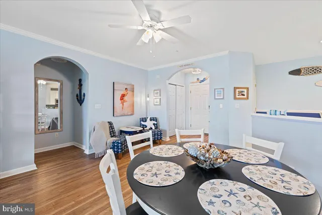 a dining room with wooden floor a chandelier a wooden table and chairs