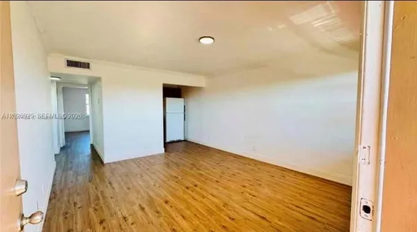 a view of empty room with wooden floor