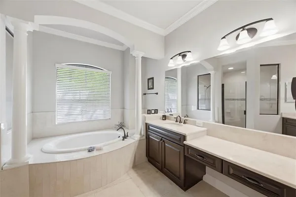 a bathroom with a tub double vanity sink and mirror