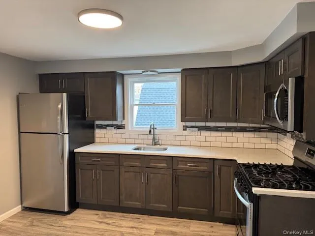 a kitchen with a sink a refrigerator and a stove