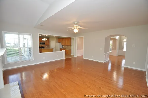 a view of an empty room with window and wooden floor