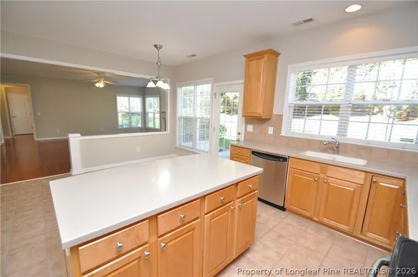 a kitchen with stainless steel appliances a sink window and cabinets