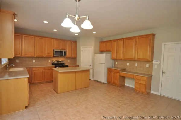 a kitchen with refrigerator cabinets and a sink