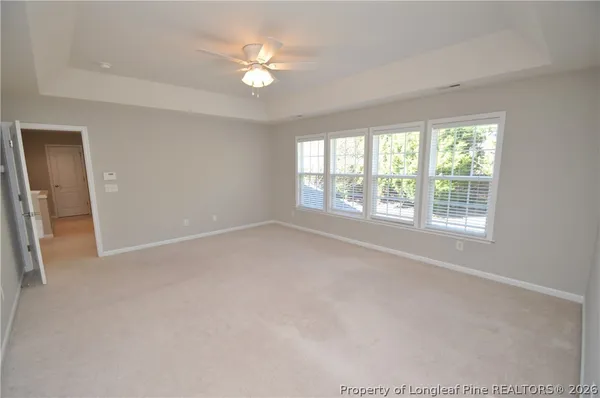 an empty room with windows and fan
