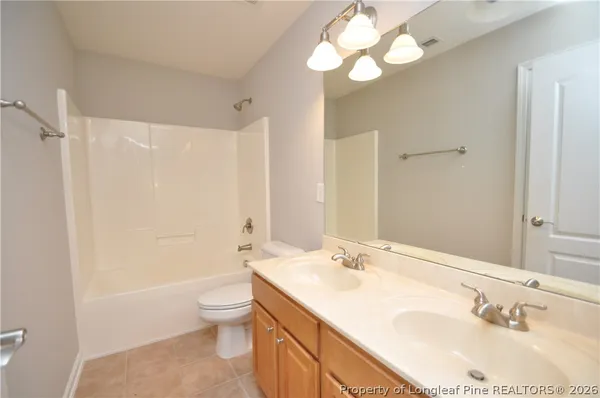 a bathroom with a sink a toilet and a large mirror