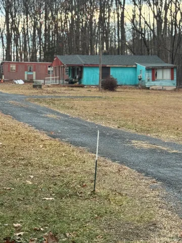 a view of a house with backyard and trees