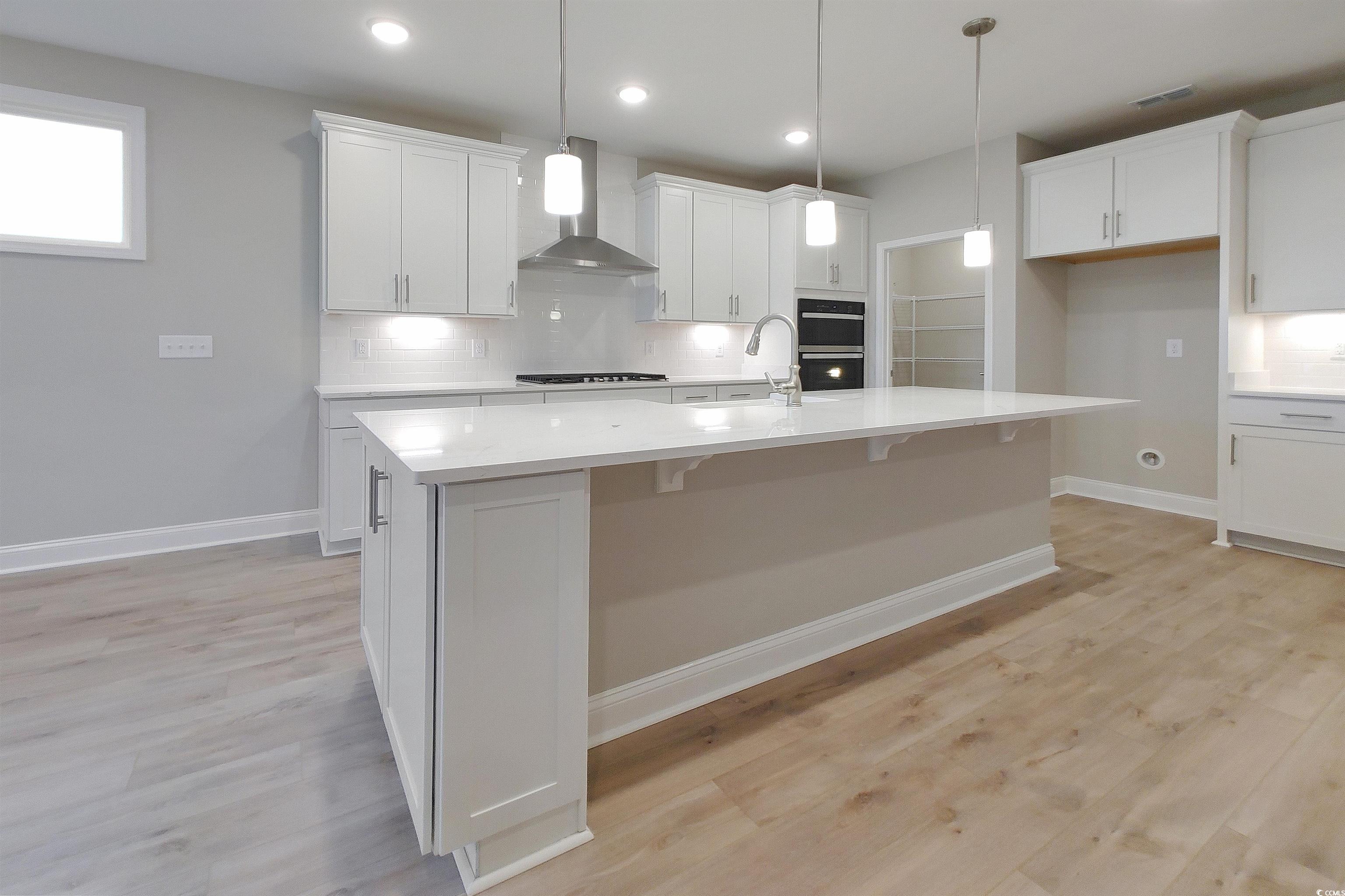1604 Littleleaf Loop North Myrtle Beach, SC 29582 - Photo 4 of 40 Kitchen featuring wall chimney range hood, an isla