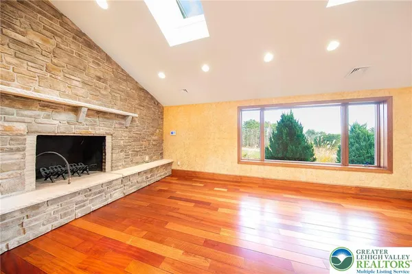a view of empty room with wooden floor and fireplace