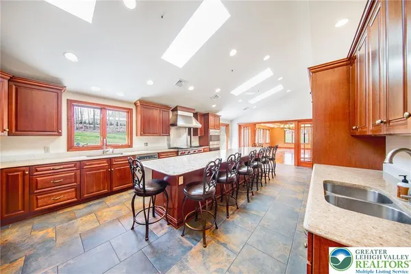 a large kitchen with lots of wooden furniture and appliances