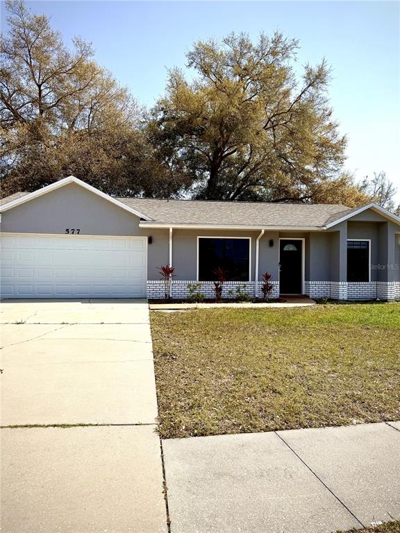 577 Wilburton Drive Deltona, FL 32738 - Photo 1 of 11 a front view of house with yard and trees in the background