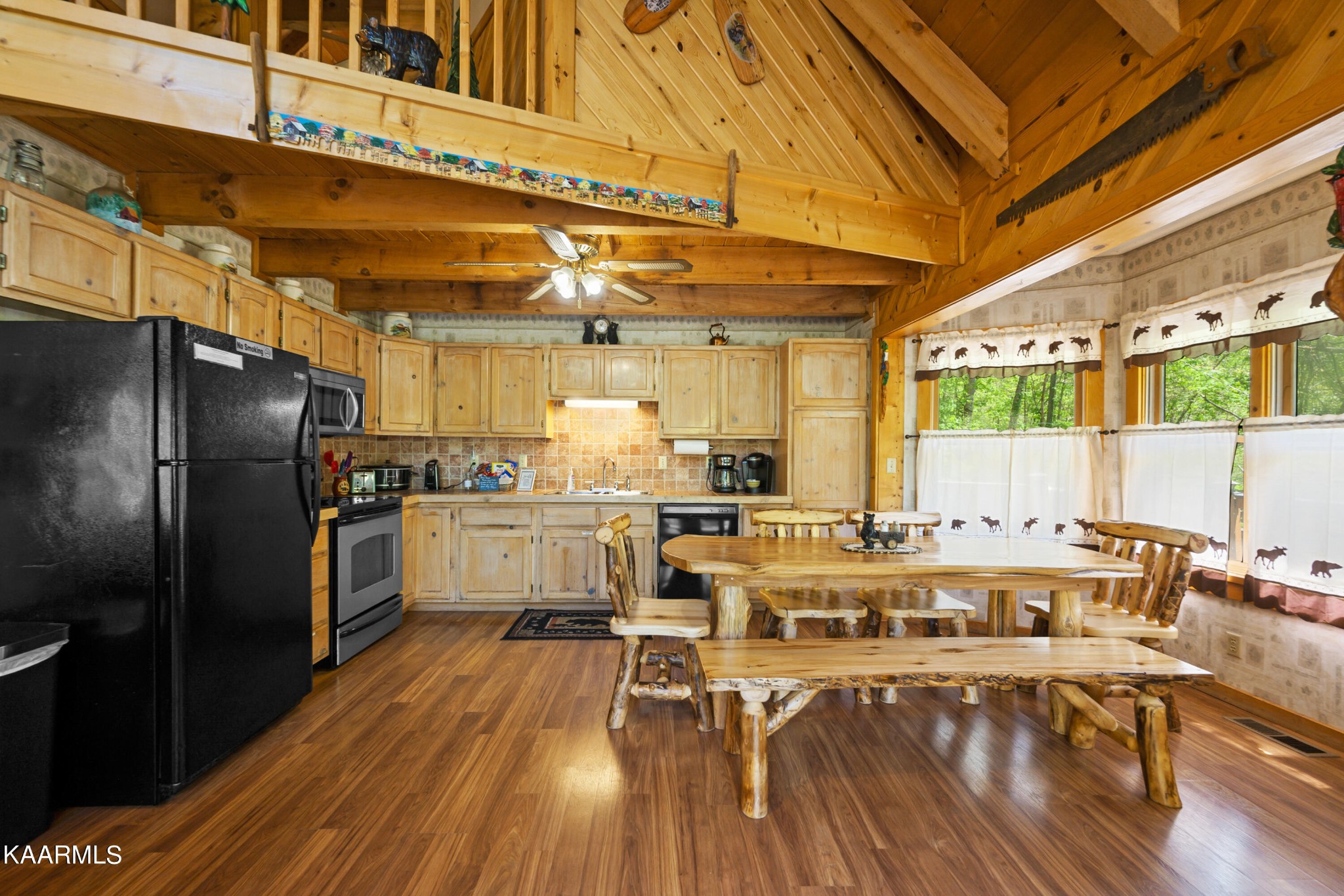3138 North Clear Fork Road Sevierville, TN 37862 - Photo 12 of 35 a kitchen with stainless steel appliances a dining table chairs stove refrigerator and cabinets