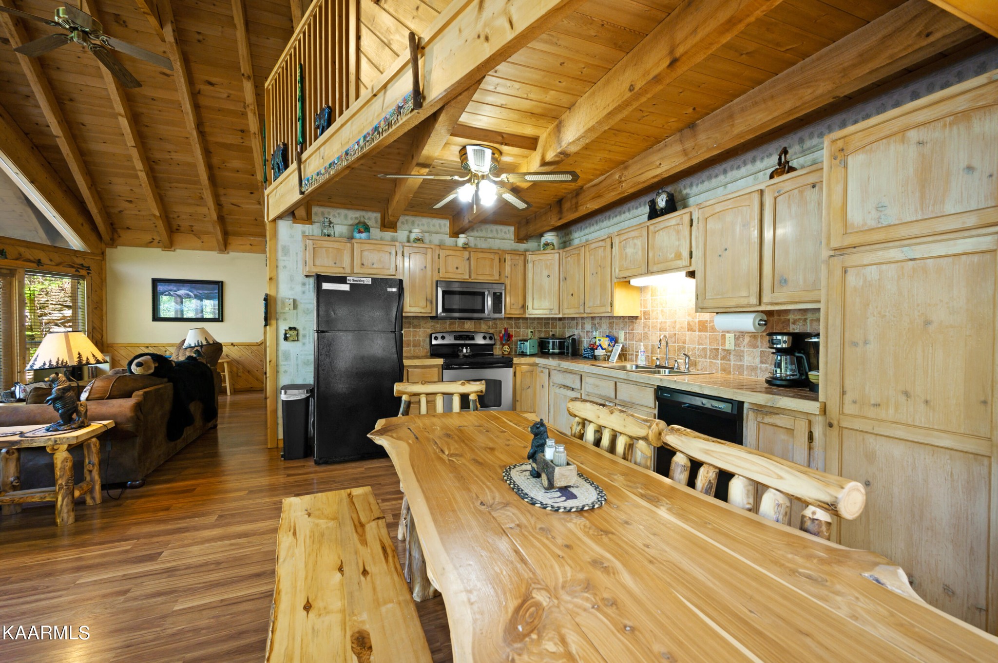 3138 North Clear Fork Road Sevierville, TN 37862 - Photo 14 of 35 a kitchen with stainless steel appliances granite countertop a refrigerator a stove top oven a sink dishwasher and dining table with wooden floor