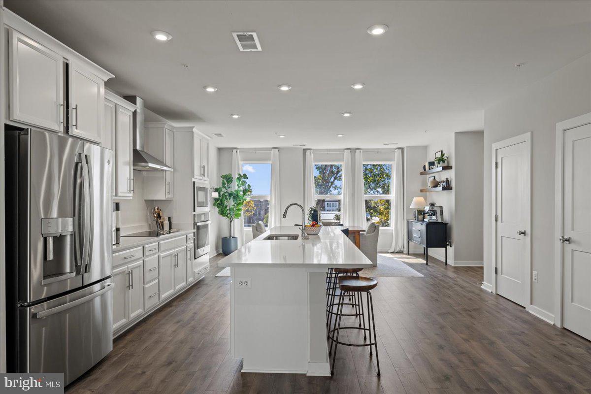 44614 Wolfhound Square Ashburn, VA 20147 - Photo 15 of 48 a large kitchen with stainless steel appliances lots of counter space and wooden floor