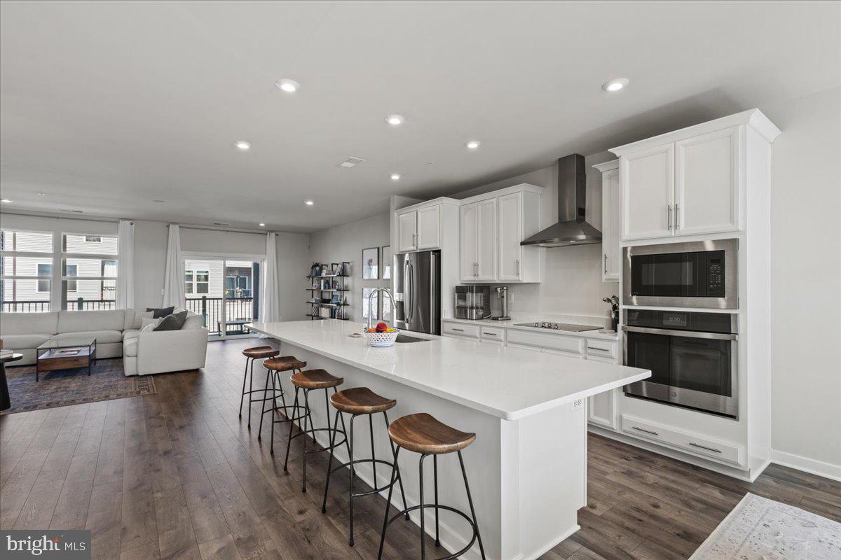 44614 Wolfhound Square Ashburn, VA 20147 - Photo 21 of 48 a kitchen with stainless steel appliances kitchen island granite countertop a stove a sink a refrigerator and white cabinets with wooden floor