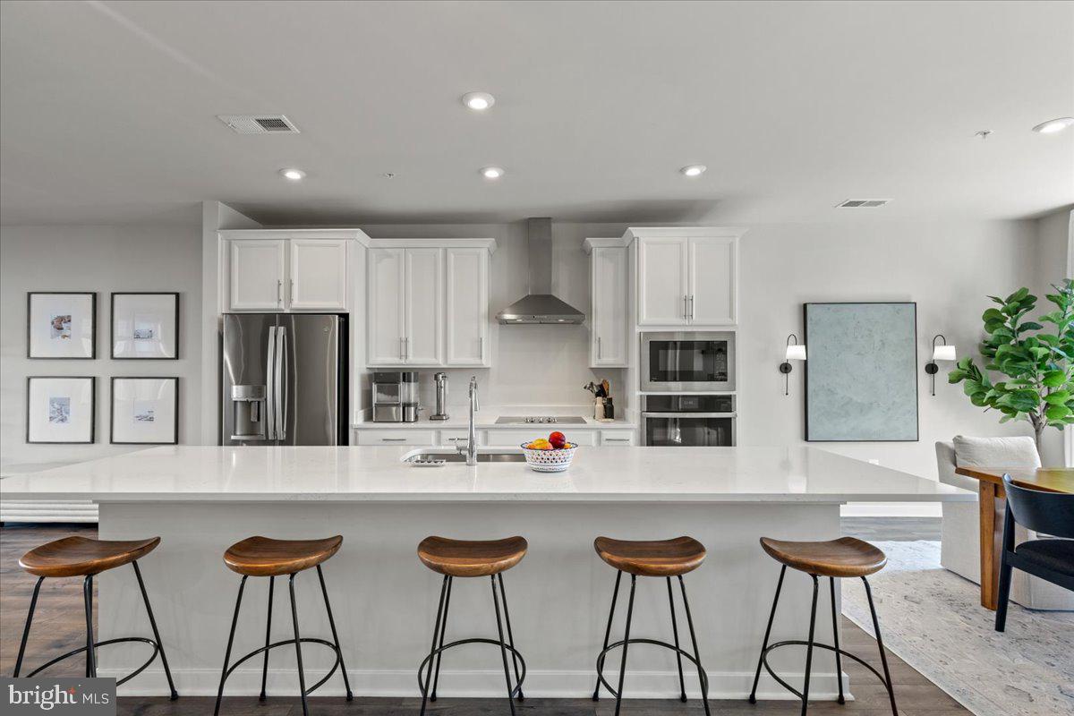 44614 Wolfhound Square Ashburn, VA 20147 - Photo 22 of 48 a kitchen with stainless steel appliances kitchen island granite countertop a table and chairs in it