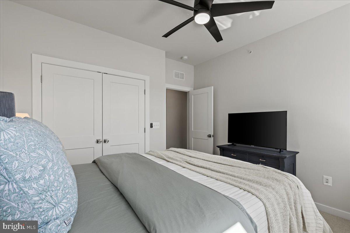 44614 Wolfhound Square Ashburn, VA 20147 - Photo 34 of 48 a bedroom with a bed and a flat tv screen on the dresser