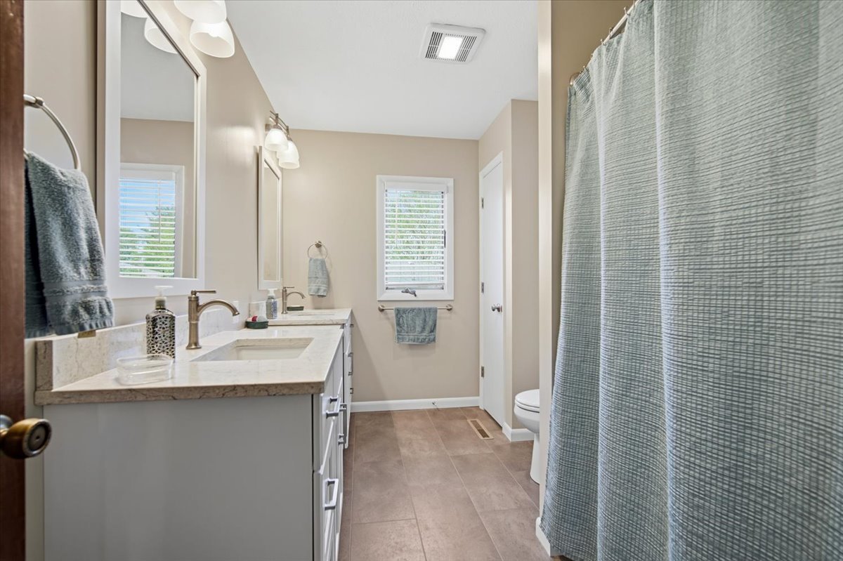 504 South School Street Minier, IL 61759 - Photo 20 of 46 a bathroom with a double vanity sink a toilet and a mirror
