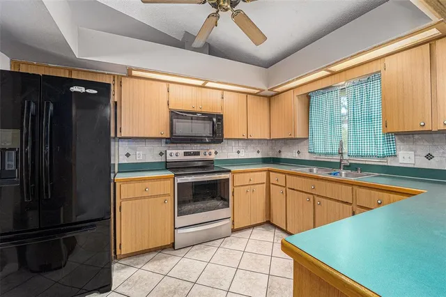 a kitchen with stainless steel appliances granite countertop a refrigerator and a sink