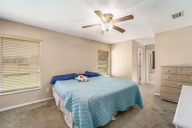 a bedroom with a bed a chandelier and a dresser
