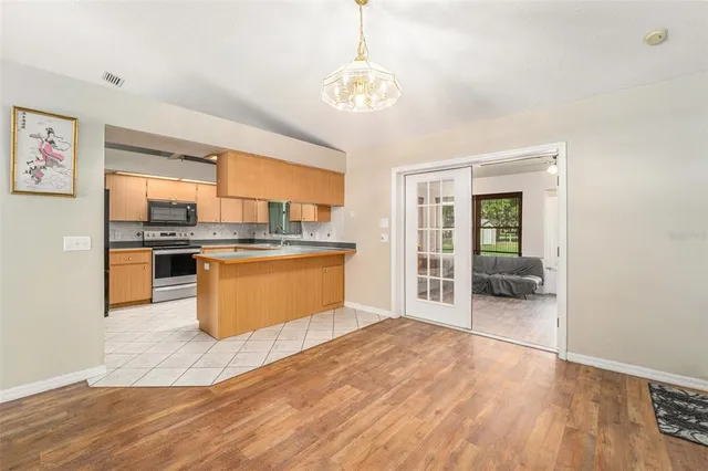 a kitchen with stainless steel appliances granite countertop a stove top oven a sink dishwasher with a dining table and chairs