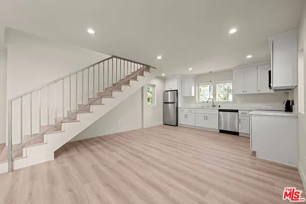 a view of a kitchen with wooden floor and electronic appliances