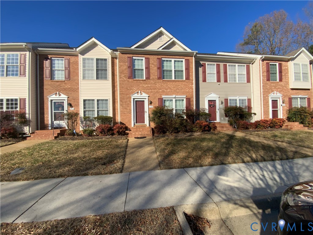Colonial inspired home featuring brick siding, a f