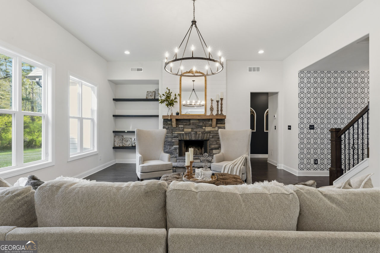 1058 Lawshe Road Senoia, GA 30276 - Photo 20 of 48 a living room with furniture a fireplace and a large window