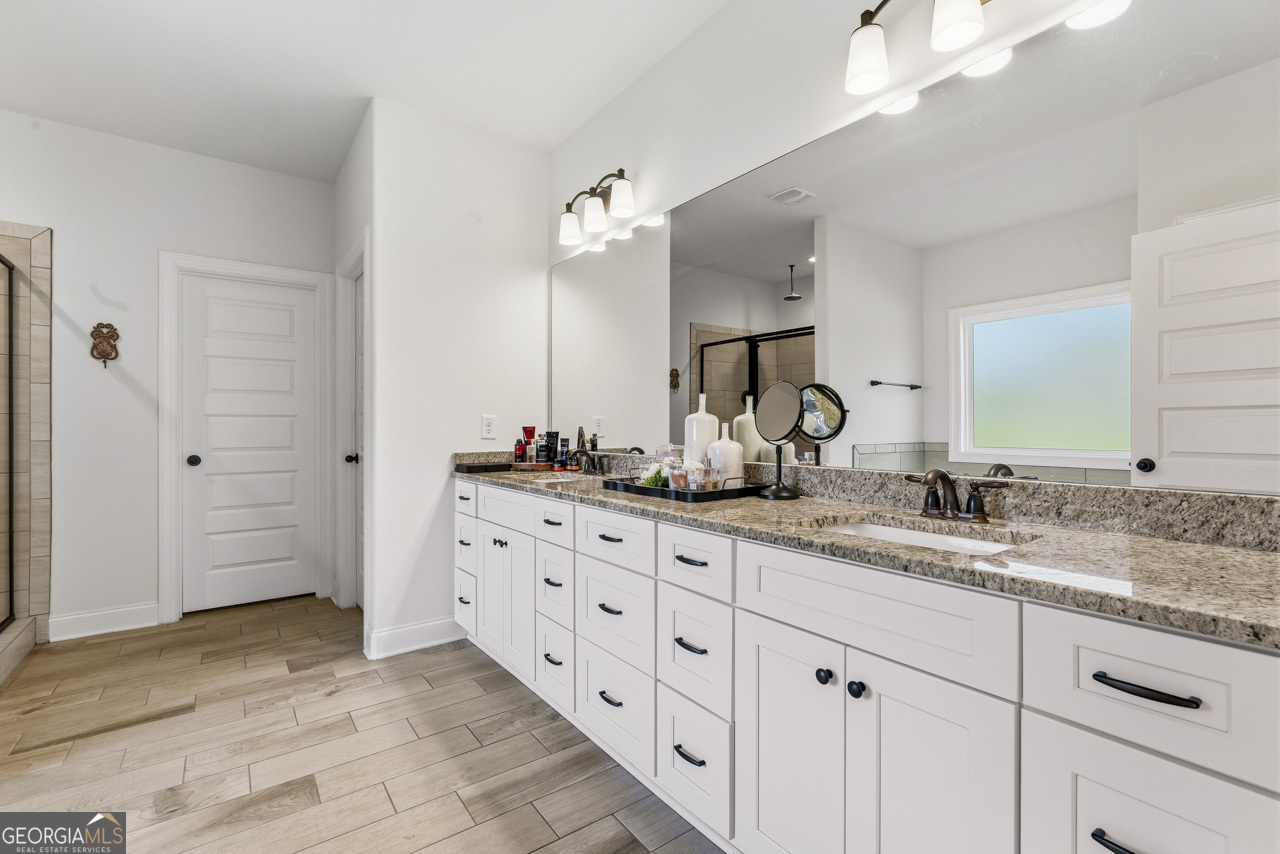 1058 Lawshe Road Senoia, GA 30276 - Photo 24 of 48 a bathroom with a granite countertop sink mirror and double