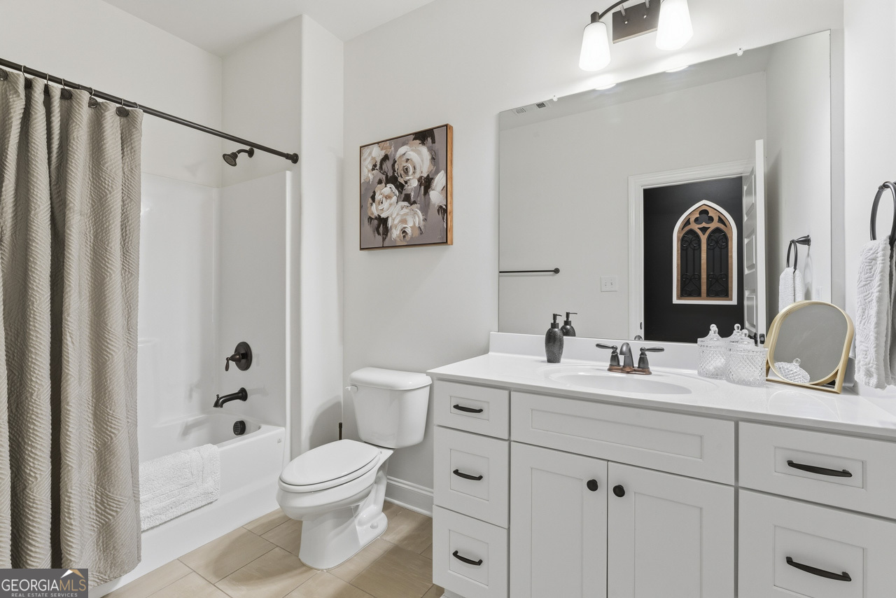 1058 Lawshe Road Senoia, GA 30276 - Photo 26 of 48 a bathroom with a toilet a sink a tub and a mirror