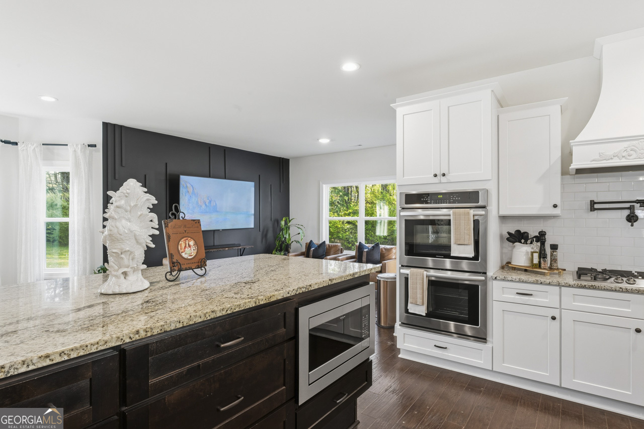 1058 Lawshe Road Senoia, GA 30276 - Photo 32 of 48 a kitchen with granite countertop a sink stove and cabinets