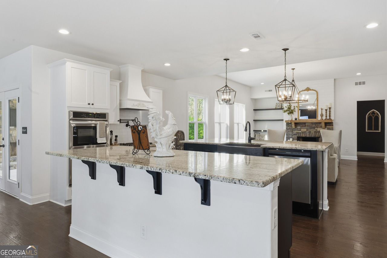1058 Lawshe Road Senoia, GA 30276 - Photo 33 of 48 a large kitchen with kitchen island white cabinets and stainless steel appliances
