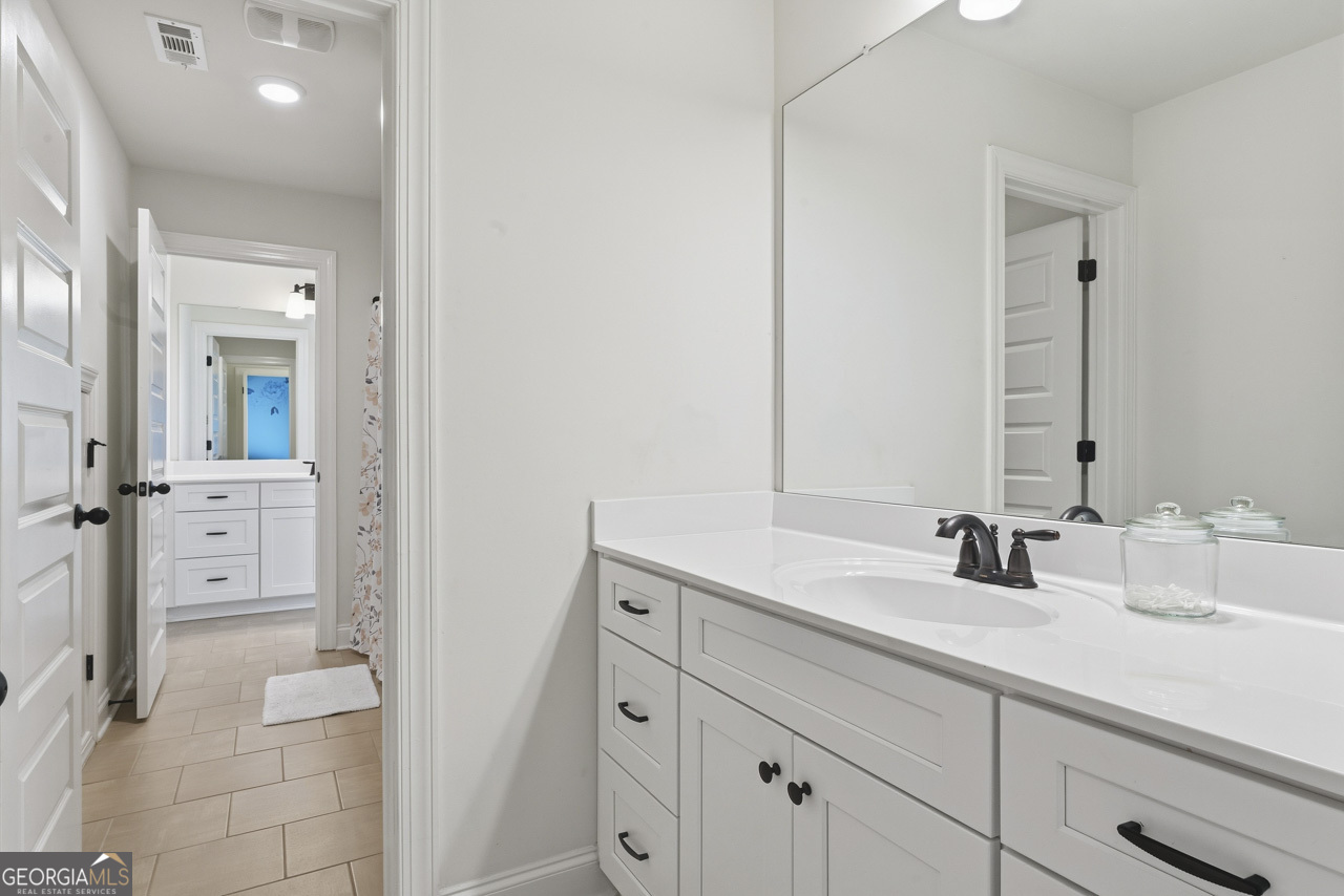 1058 Lawshe Road Senoia, GA 30276 - Photo 40 of 48 a bathroom with a double vanity sink mirror and
