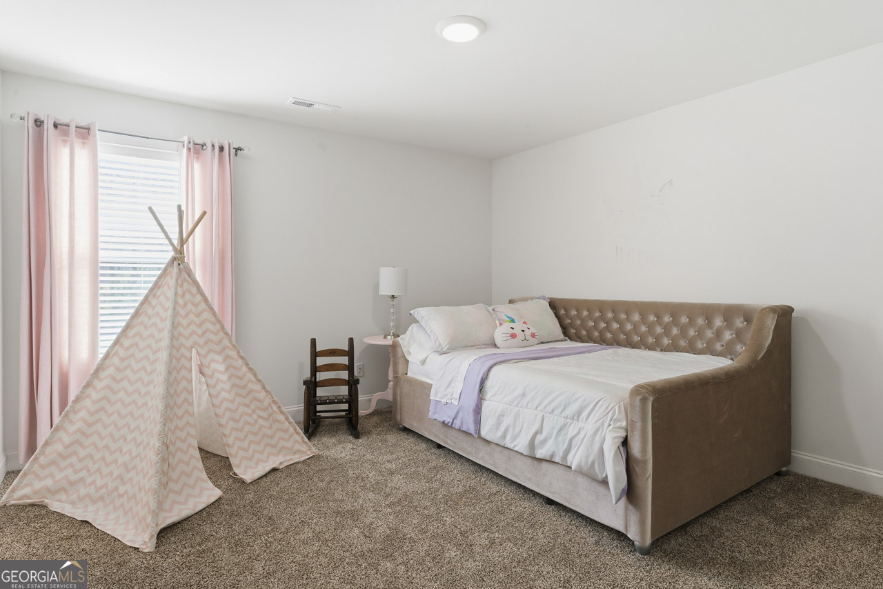 1058 Lawshe Road Senoia, GA 30276 - Photo 42 of 48 a bed sitting in a room next to a window