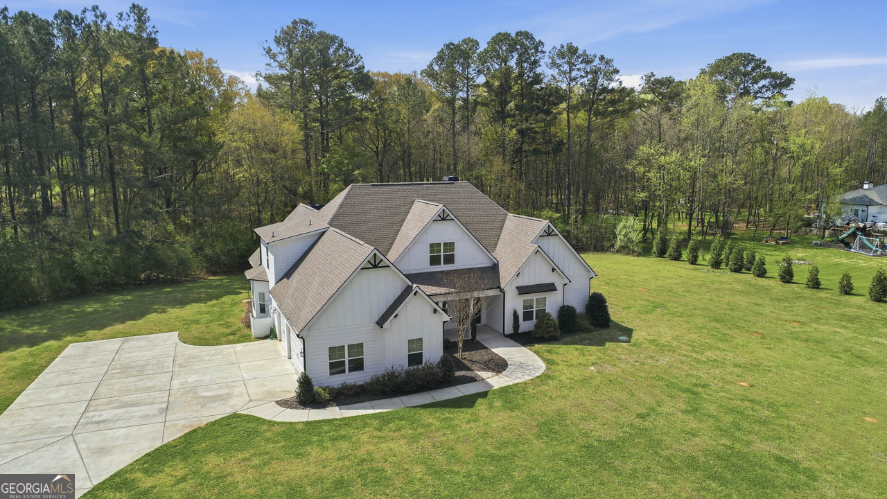 1058 Lawshe Road Senoia, GA 30276 - Photo 5 of 48 a view of a small house in a big yard with large trees