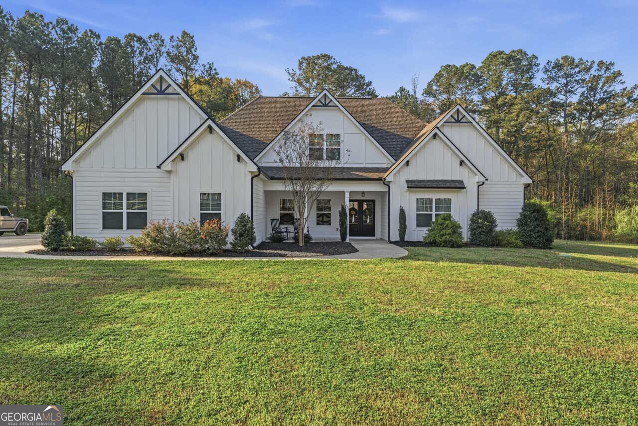 1058 Lawshe Road Senoia, GA 30276 - Photo 6 of 48 a front view of a house with a garden and porch