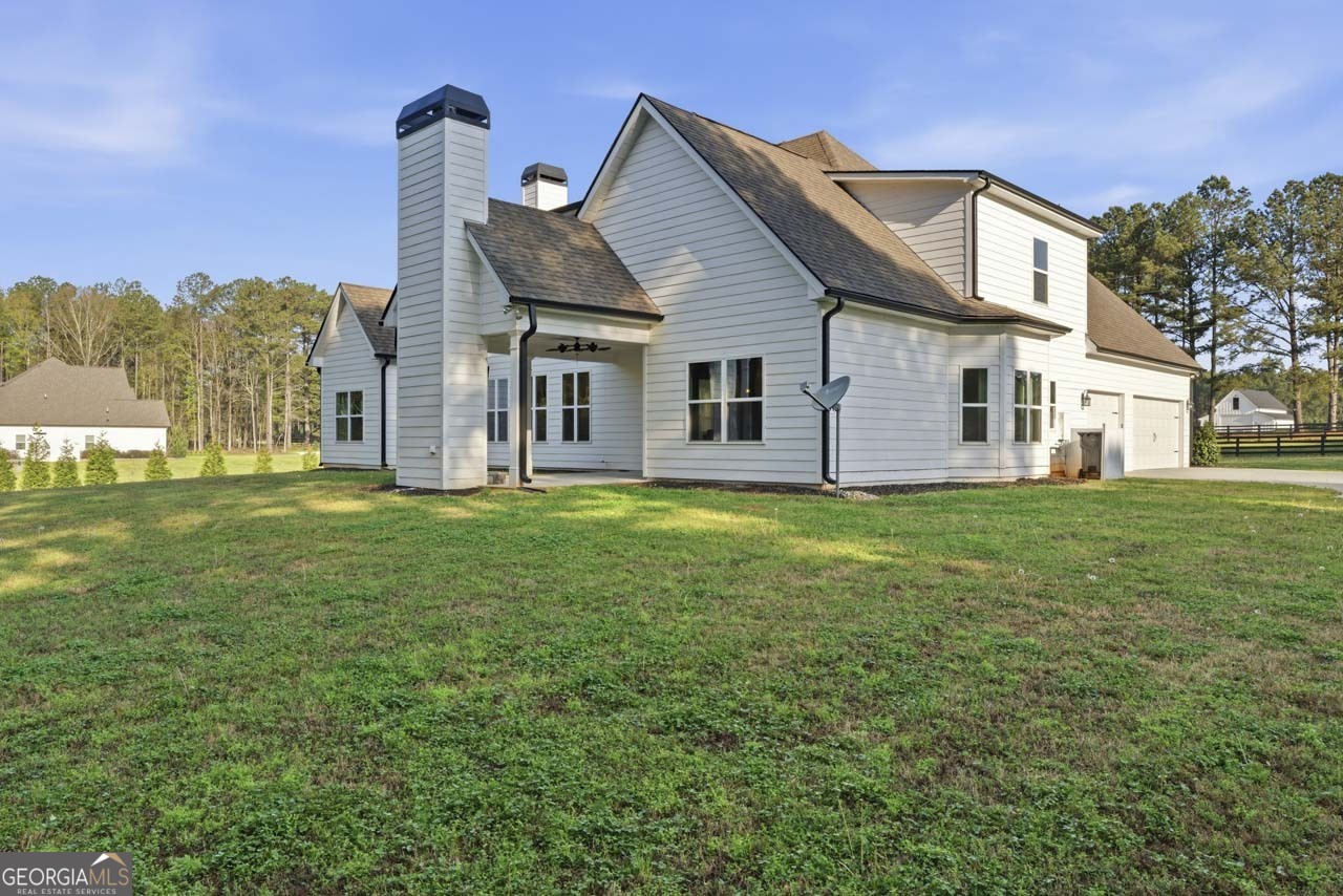 1058 Lawshe Road Senoia, GA 30276 - Photo 9 of 48 a front view of house with yard and trees in the background