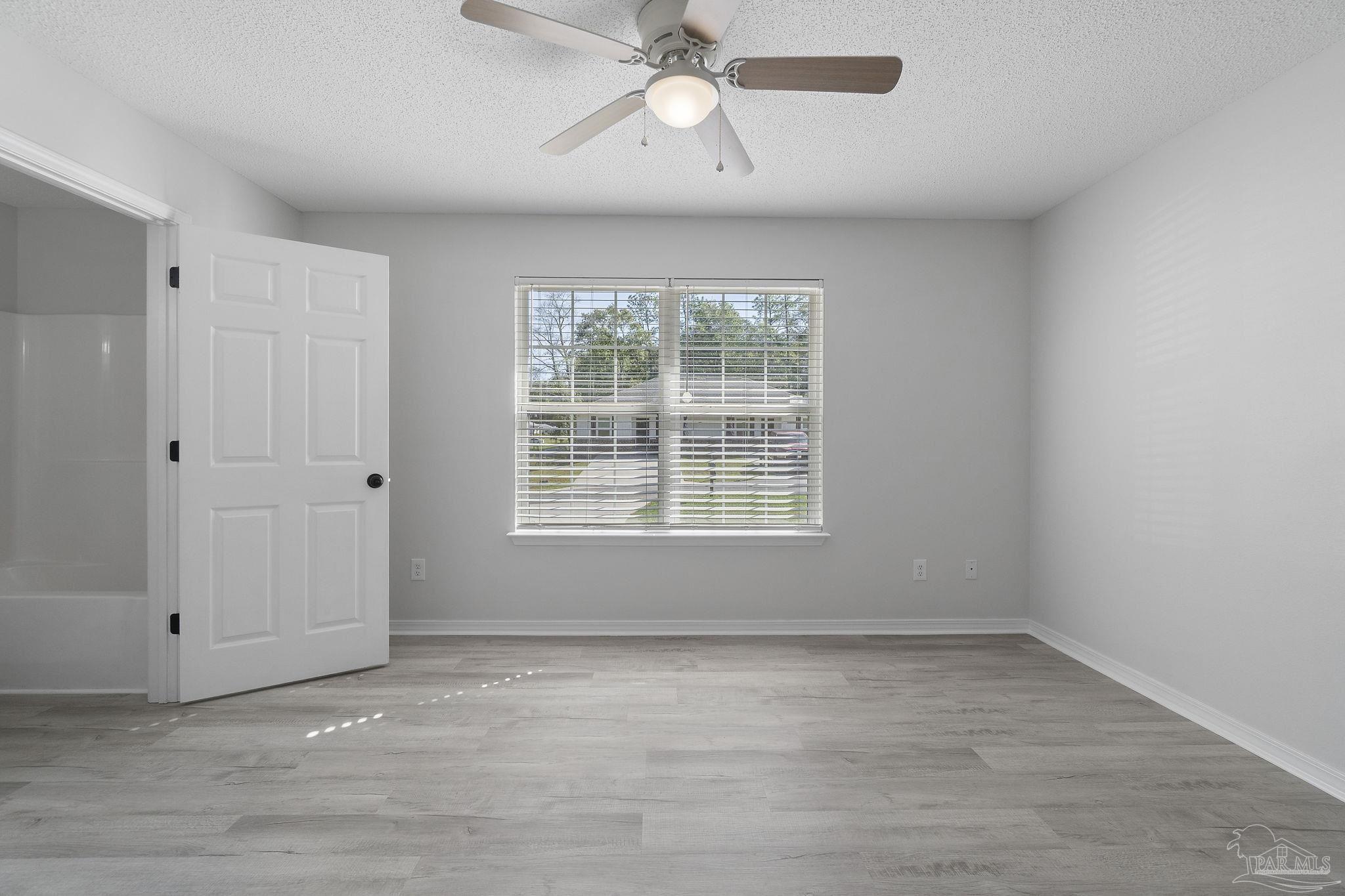 7253 Pro Lane Milton, FL 32570 - Photo 15 of 33 an empty room with chandelier fan and windows