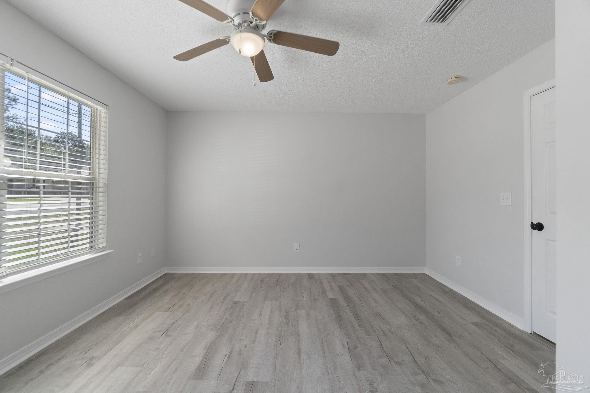 7253 Pro Lane Milton, FL 32570 - Photo 18 of 33 an empty room with a window and a ceiling fan