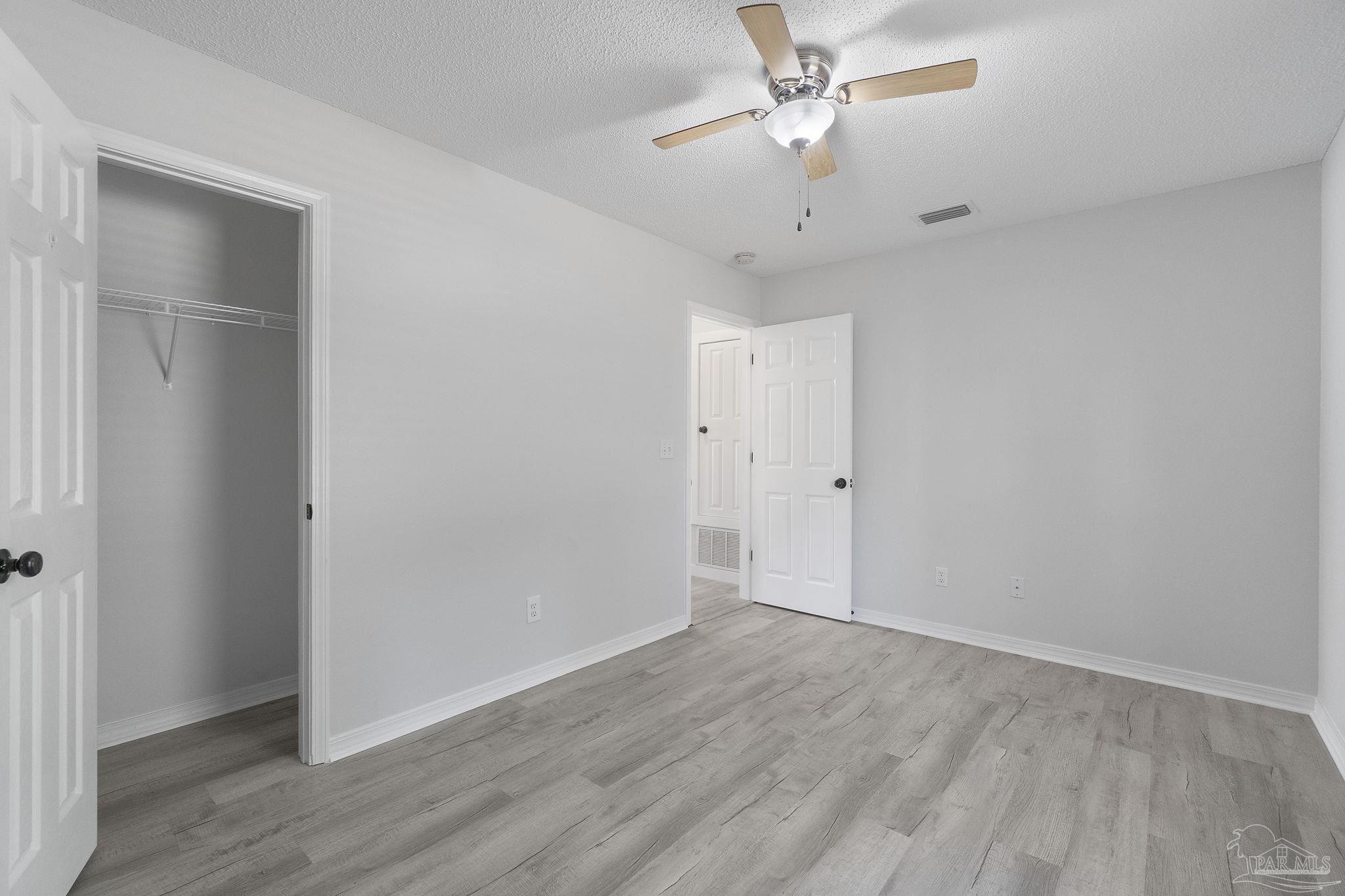 7253 Pro Lane Milton, FL 32570 - Photo 23 of 33 an empty room with wooden floor and ceiling fan