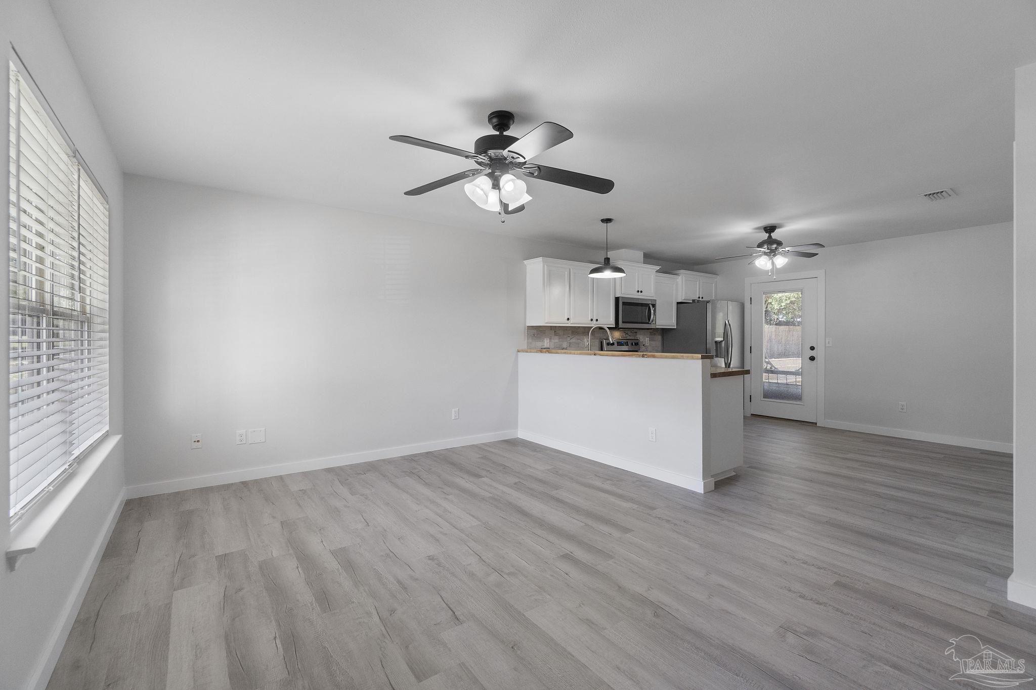 7253 Pro Lane Milton, FL 32570 - Photo 6 of 33 a view of a kitchen with a dishwasher cabinets and wooden floor