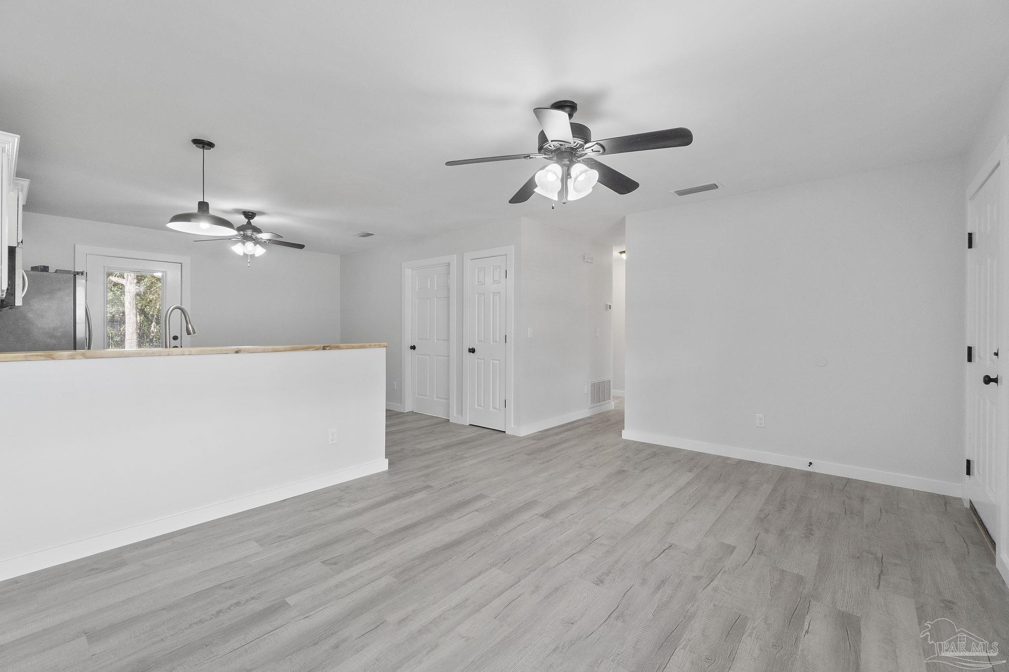 7253 Pro Lane Milton, FL 32570 - Photo 8 of 33 a view of a kitchen with wooden floor and ceiling fan