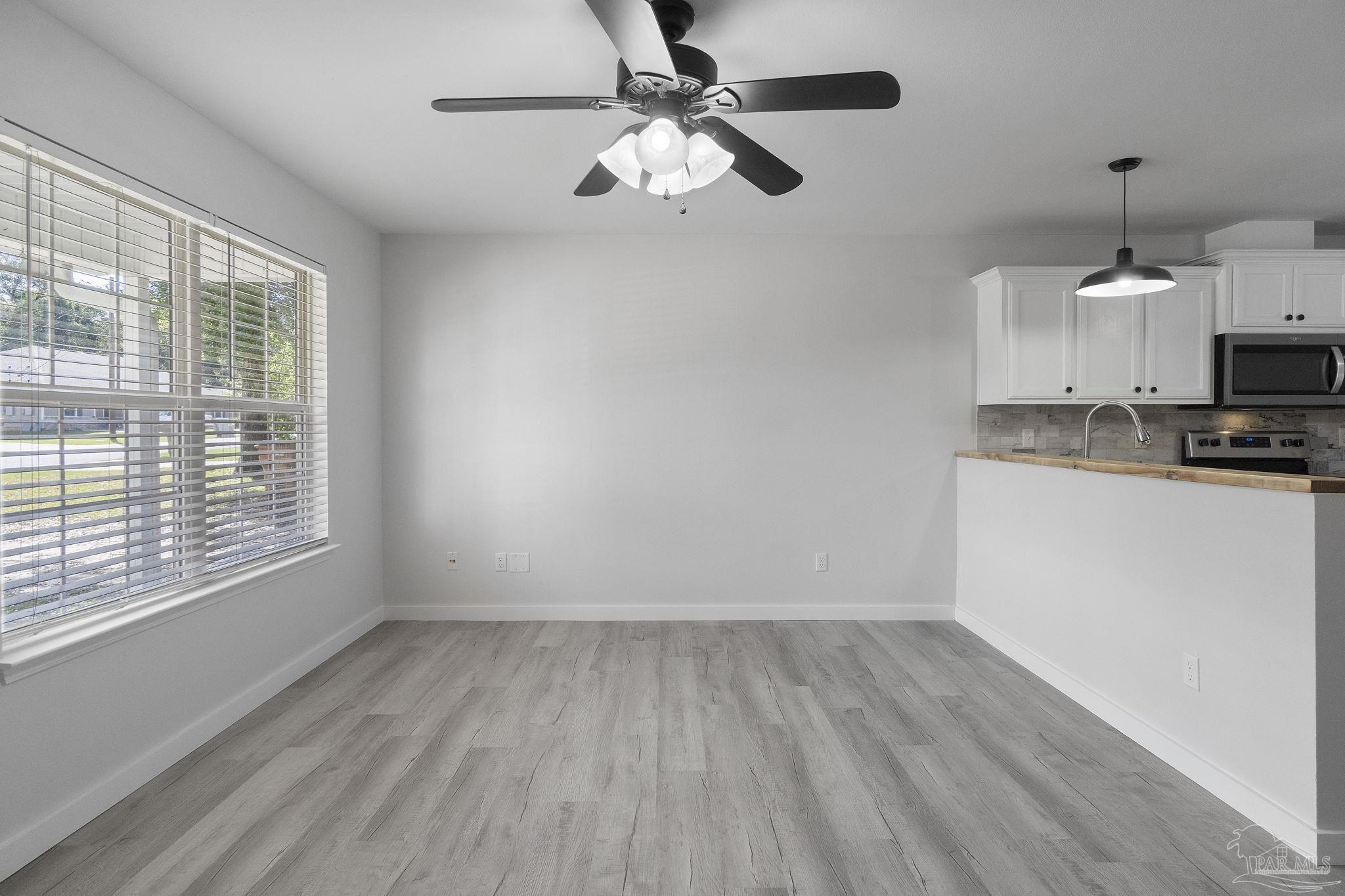7253 Pro Lane Milton, FL 32570 - Photo 9 of 33 a view of kitchen and microwave with wooden floor